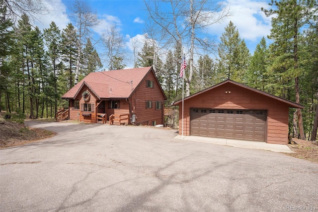view of front facade featuring a detached garage and an outdoor structure