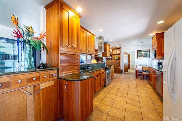 kitchen with stainless steel appliances, dark stone counters, light tile patterned flooring, extractor fan, and decorative light fixtures