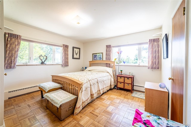 bedroom featuring light parquet flooring, a baseboard radiator, and multiple windows