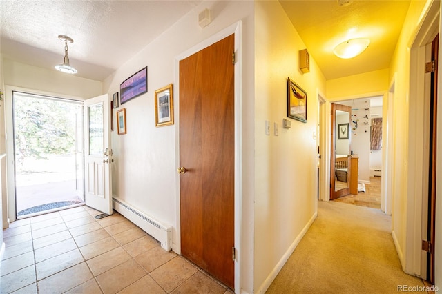 corridor with a baseboard radiator, a textured ceiling, and light tile patterned flooring