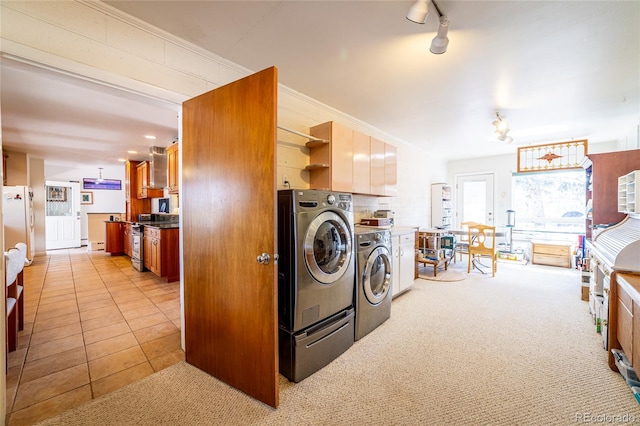 clothes washing area featuring washing machine and dryer and light carpet