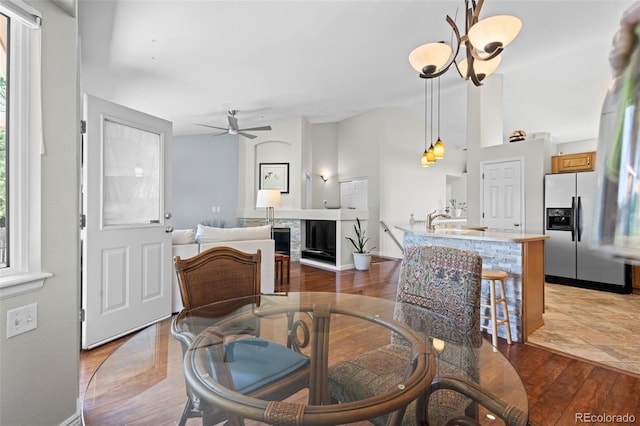 1376 Banner Cir, Erie, CO 80516 - dining area with ceiling fan, wood finished floors, a fireplace, and healthy amount of natural light