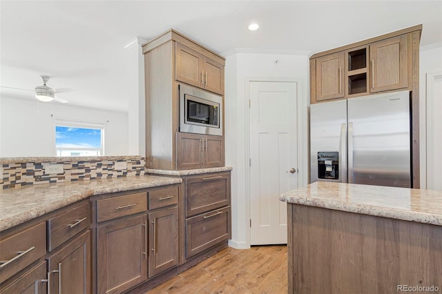 kitchen featuring ceiling fan, stainless steel appliances, light stone countertops, and decorative backsplash