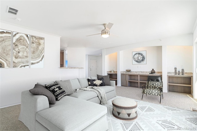 living room featuring ceiling fan and light colored carpet