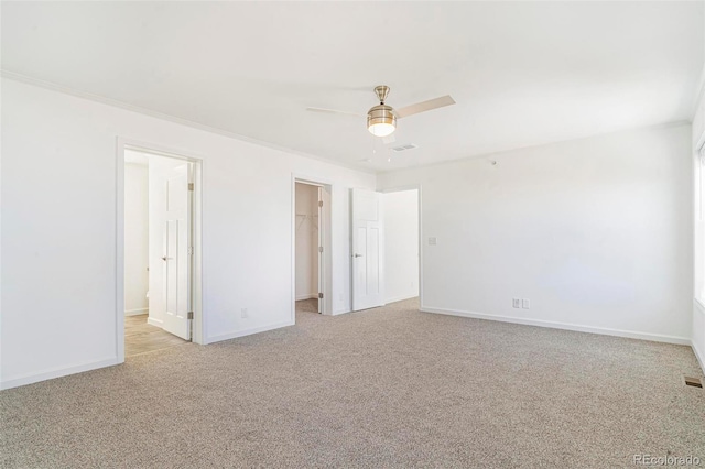 unfurnished bedroom featuring a spacious closet, light carpet, ceiling fan, and a closet