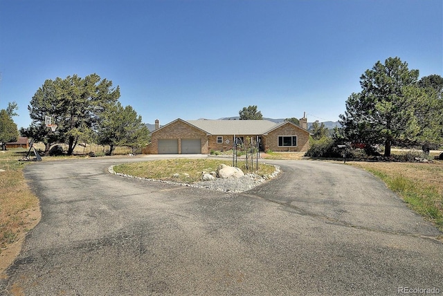 510 Crossman Ave, Buena Vista, CO 81211 - ranch-style home with driveway, an attached garage, a chimney, and brick siding