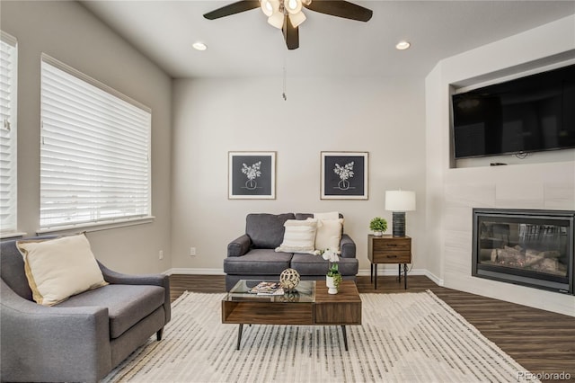 living area with recessed lighting, a fireplace, baseboards, and wood finished floors