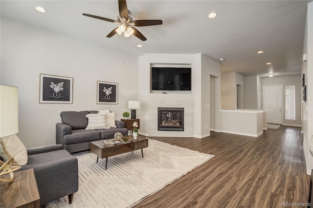 living area with baseboards, a tile fireplace, ceiling fan, dark wood-type flooring, and recessed lighting