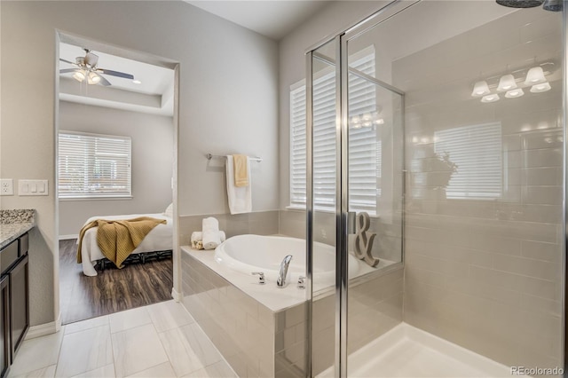 ensuite bathroom featuring a stall shower, ceiling fan, tile patterned floors, vanity, and a bath