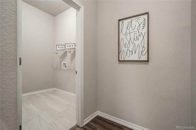 clothes washing area with hookup for a washing machine, baseboards, laundry area, and wood finished floors