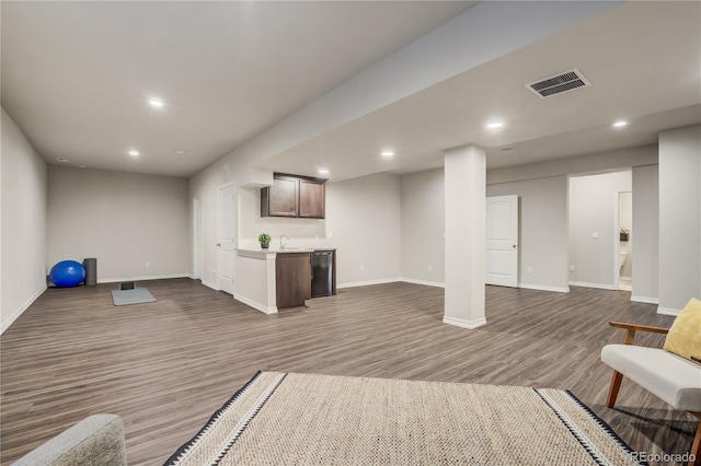 interior space with recessed lighting, dark wood-style flooring, a sink, visible vents, and baseboards