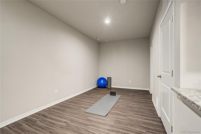 exercise room with baseboards, dark wood-type flooring, and recessed lighting