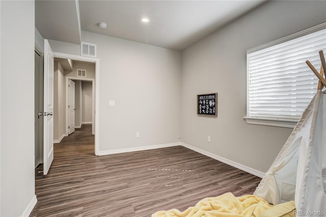 unfurnished bedroom with baseboards, visible vents, wood finished floors, and recessed lighting