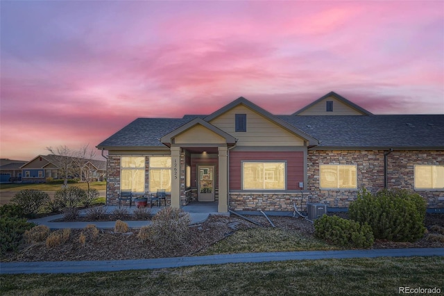 12625 Madison Way, Thornton, CO 80241 - bungalow-style home with a porch, stone siding, central AC unit, and a shingled roof