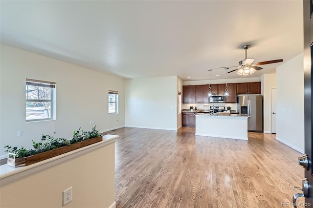 12625 Madison Way, Thornton, CO 80241 - unfurnished living room with light wood-style flooring, baseboards, a ceiling fan, and recessed lighting