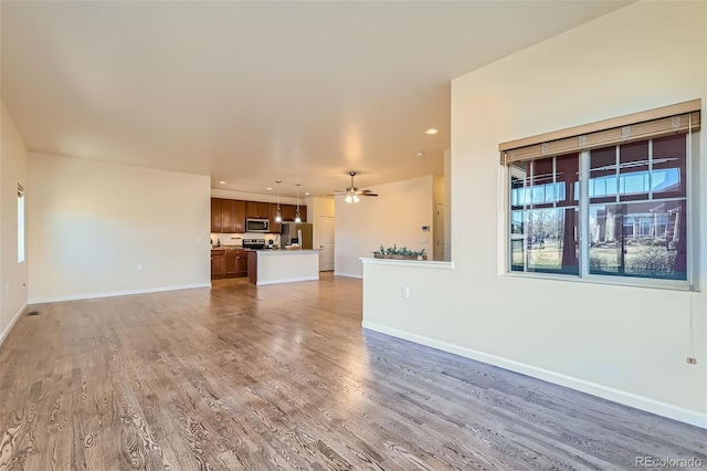 12625 Madison Way, Thornton, CO 80241 - unfurnished living room featuring light wood-type flooring, ceiling fan, baseboards, and recessed lighting