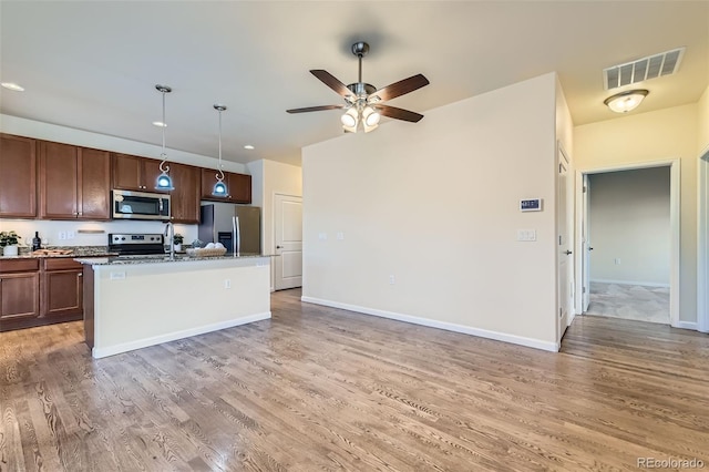 12625 Madison Way, Thornton, CO 80241 - kitchen with stainless steel appliances, visible vents, a ceiling fan, and light wood-style flooring
