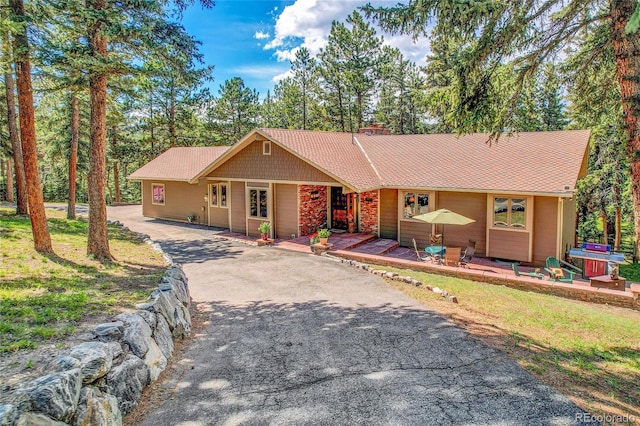 7753 Red Fox Dr, Evergreen, CO 80439 - ranch-style home featuring asphalt driveway, stone siding, and a chimney