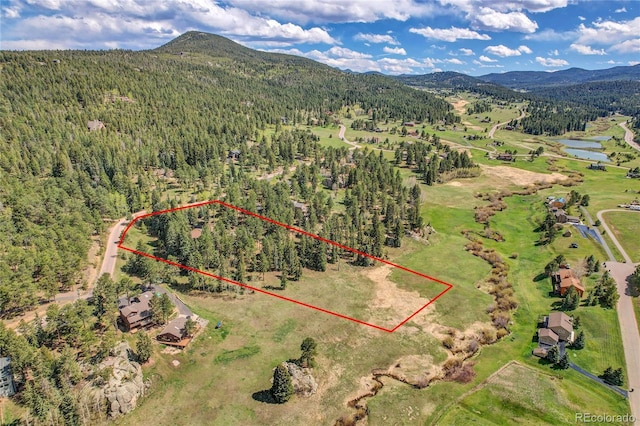 7753 Red Fox Dr, Evergreen, CO 80439 - aerial view of property and surrounding area featuring a forest, property boundaries highlighted, and a water and mountain view