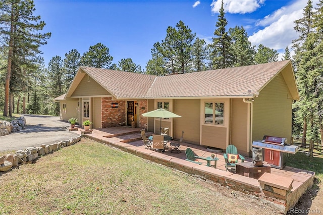 7753 Red Fox Dr, Evergreen, CO 80439 - rear view of property featuring a patio, a yard, and roof with shingles