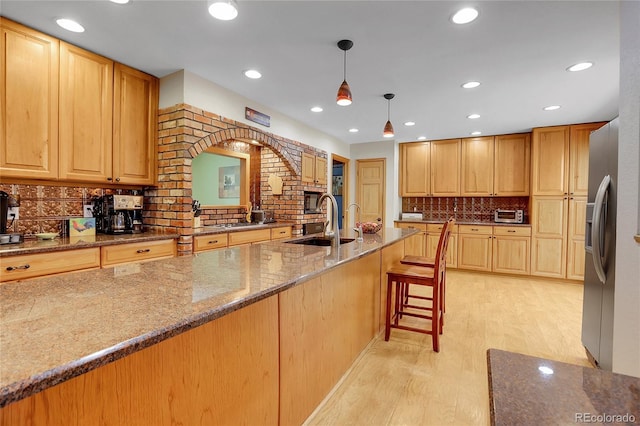 7753 Red Fox Dr, Evergreen, CO 80439 - kitchen with a sink, light wood-style floors, decorative backsplash, stone countertops, and black microwave