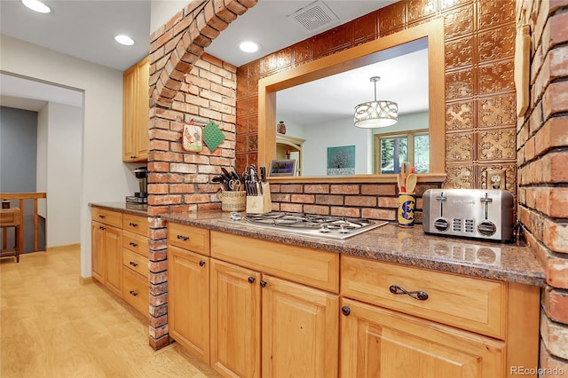 7753 Red Fox Dr, Evergreen, CO 80439 - kitchen with stainless steel gas stovetop, decorative backsplash, and dark stone counters