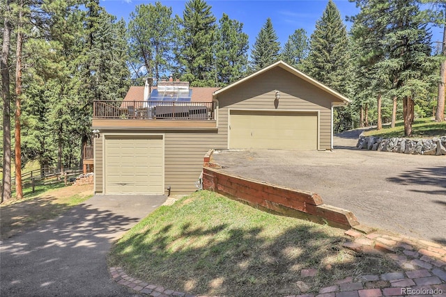 7753 Red Fox Dr, Evergreen, CO 80439 - view of front facade featuring a garage, a balcony, and asphalt driveway