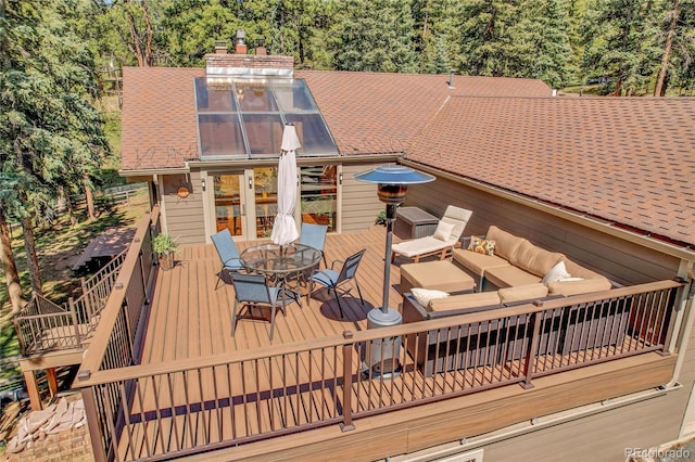 7753 Red Fox Dr, Evergreen, CO 80439 - wooden terrace featuring outdoor dining area, a wooded view, and an outdoor hangout area