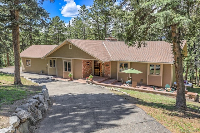 7753 Red Fox Dr, Evergreen, CO 80439 - single story home with driveway, covered porch, and a chimney