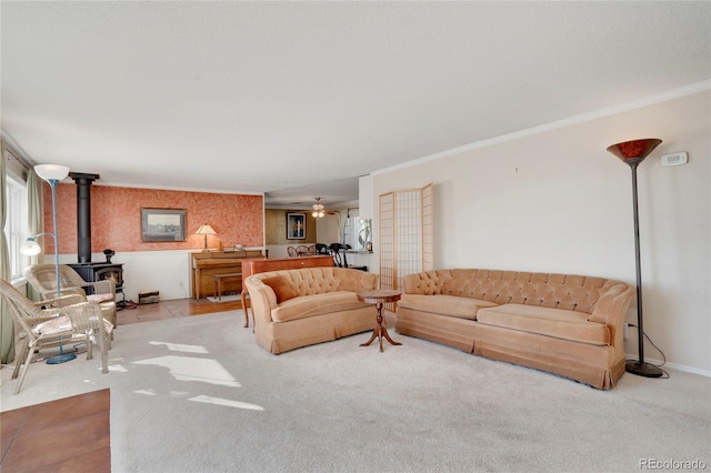 carpeted living room with crown molding, a wood stove, and ceiling fan