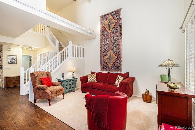 8300 Fairmount Dr Unit M103, Denver, CO 80247 - living area with stairs, wood finished floors, a towering ceiling, and baseboards