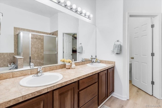 3862 E 127th Ln, Thornton, CO 80241 - bathroom with double vanity, a stall shower, wood finished floors, and a garden tub