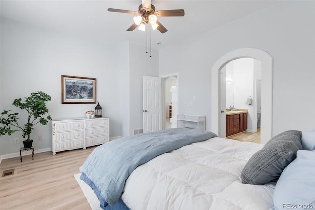 3862 E 127th Ln, Thornton, CO 80241 - bedroom featuring arched walkways, light wood-style flooring, a ceiling fan, and connected bathroom