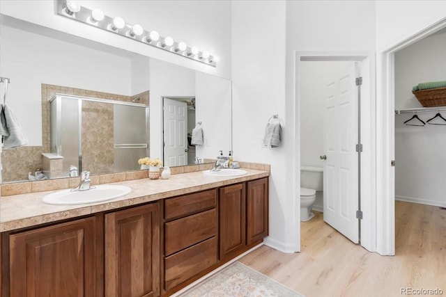 3862 E 127th Ln, Thornton, CO 80241 - bathroom featuring a stall shower, double vanity, and wood finished floors