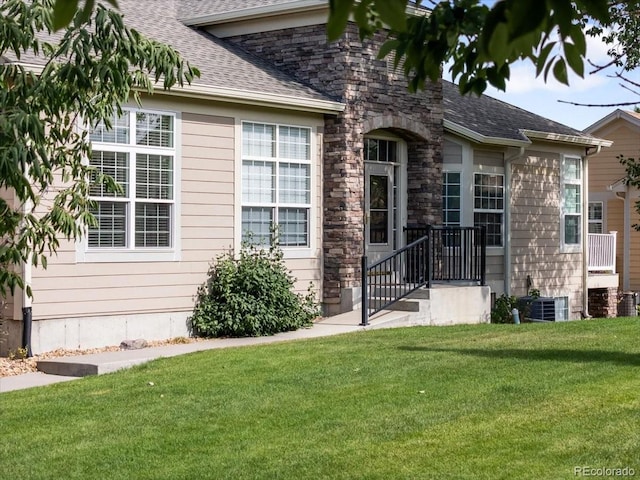 3862 E 127th Ln, Thornton, CO 80241 - view of exterior entry featuring a yard, roof with shingles, and stone siding