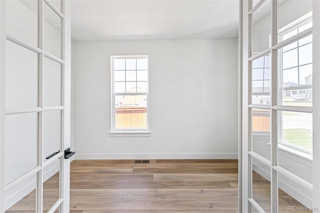 28564 E 6th Pl, Watkins, CO 80137 - unfurnished bedroom featuring multiple windows, french doors, and light wood-style flooring