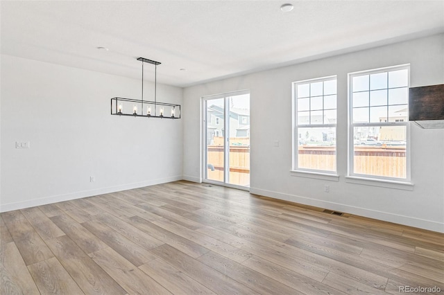 28564 E 6th Pl, Watkins, CO 80137 - unfurnished room with a chandelier and light wood finished floors