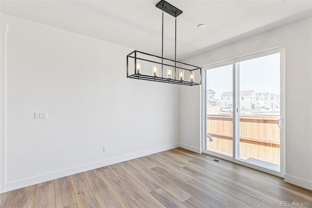 28564 E 6th Pl, Watkins, CO 80137 - unfurnished dining area with wood finished floors and a chandelier