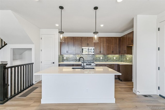 28564 E 6th Pl, Watkins, CO 80137 - kitchen featuring appliances with stainless steel finishes, light countertops, light wood-style floors, tasteful backsplash, and recessed lighting
