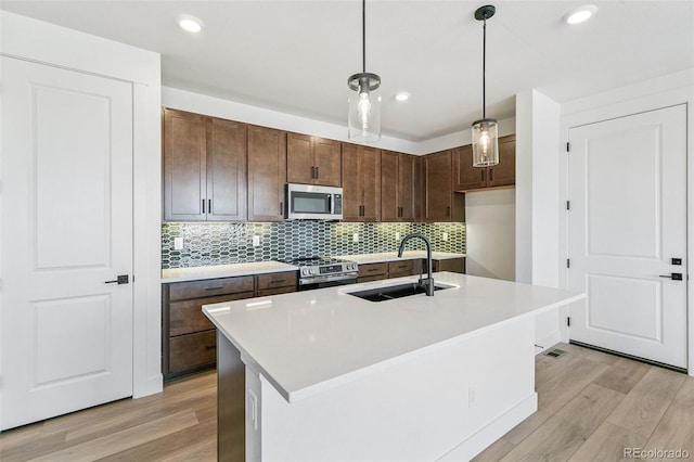 28564 E 6th Pl, Watkins, CO 80137 - kitchen with stainless steel appliances, light wood finished floors, tasteful backsplash, light countertops, and recessed lighting