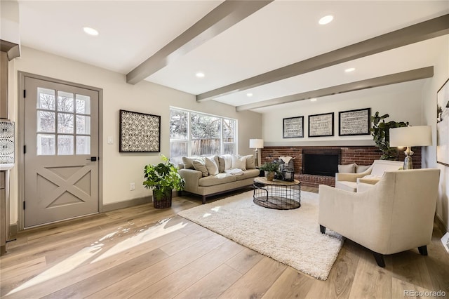 living room with a brick fireplace, beam ceiling, and light hardwood / wood-style floors