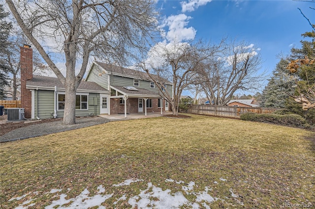 rear view of house featuring a patio, cooling unit, and a lawn