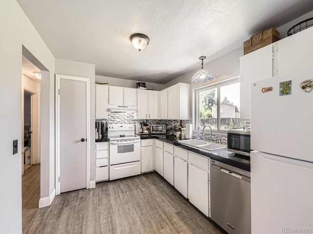 10895 Fairfax Way, Thornton, CO 80233 - kitchen featuring stainless steel appliances, under cabinet range hood, wood finished floors, decorative backsplash, and white cabinets