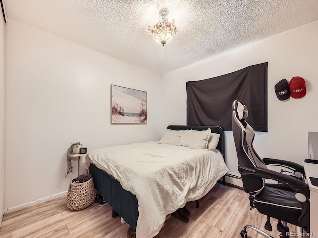 10895 Fairfax Way, Thornton, CO 80233 - bedroom with wood finished floors, a textured ceiling, an office area, and baseboard heating