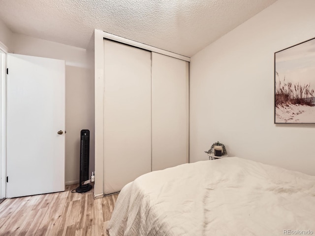 10895 Fairfax Way, Thornton, CO 80233 - bedroom featuring light wood-style floors, a closet, and a textured ceiling