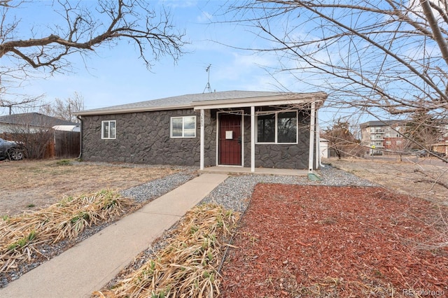 view of front of home with a shingled roof and stone siding