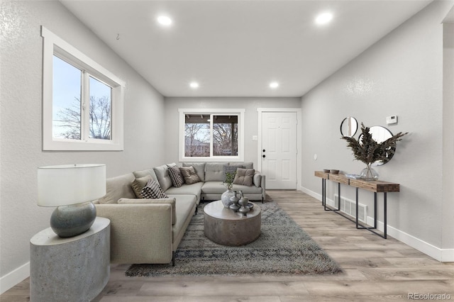 living area featuring recessed lighting, baseboards, and wood finished floors