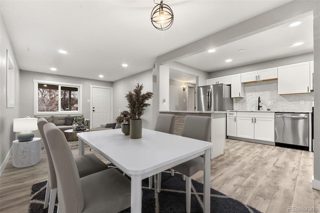 dining room featuring light wood-style floors, baseboards, and recessed lighting