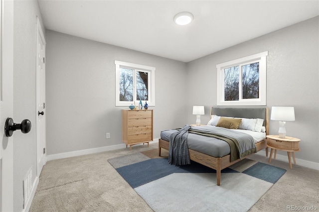 bedroom with light carpet, visible vents, and baseboards