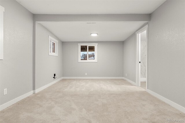 carpeted spare room featuring baseboards